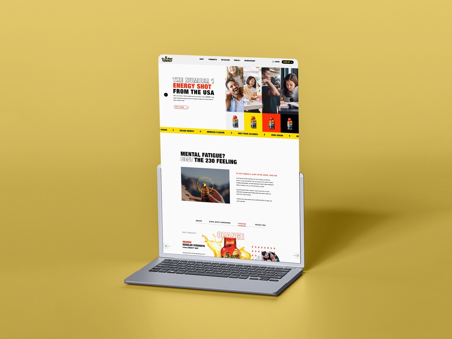 A laptop displays a vibrant website about energy shots with a yellow background.